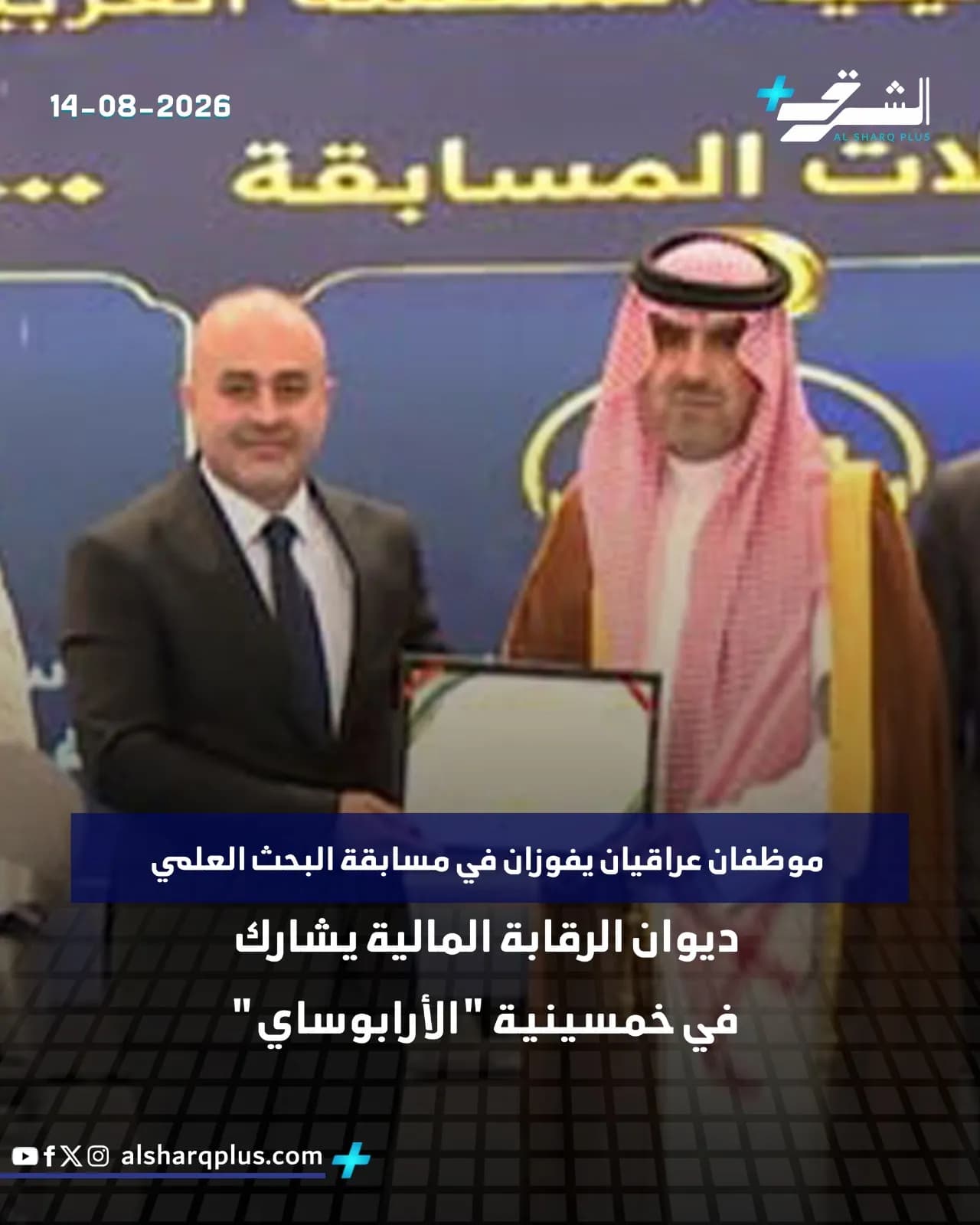 رجل يرتدي بدلة سوداء وآخر يرتدي زيًا عربيًا تقليديًا يقفان بجانب بعضهما، الأول يحمل شهادة.