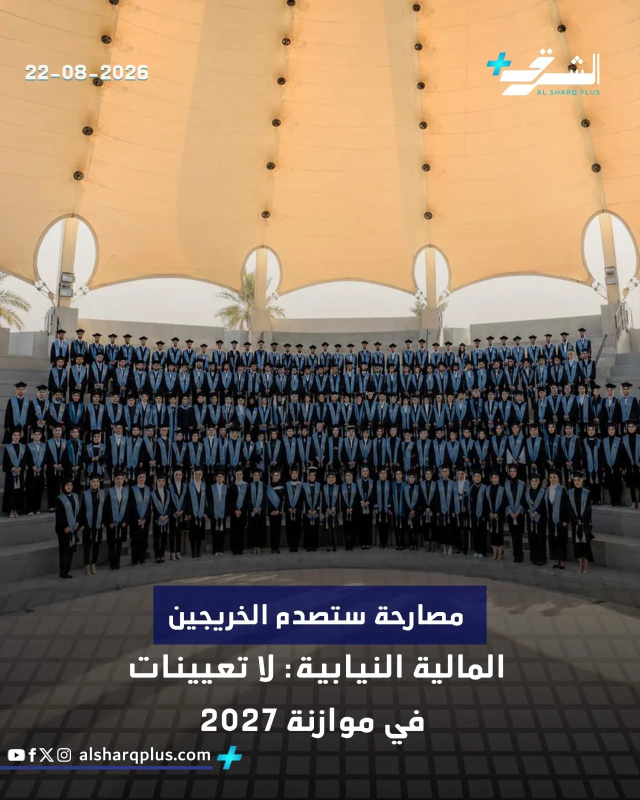 صورة جماعية لمتخرجين يرتدون أردية التخرج تحت مظلة ضخمة في يوم مشمس.