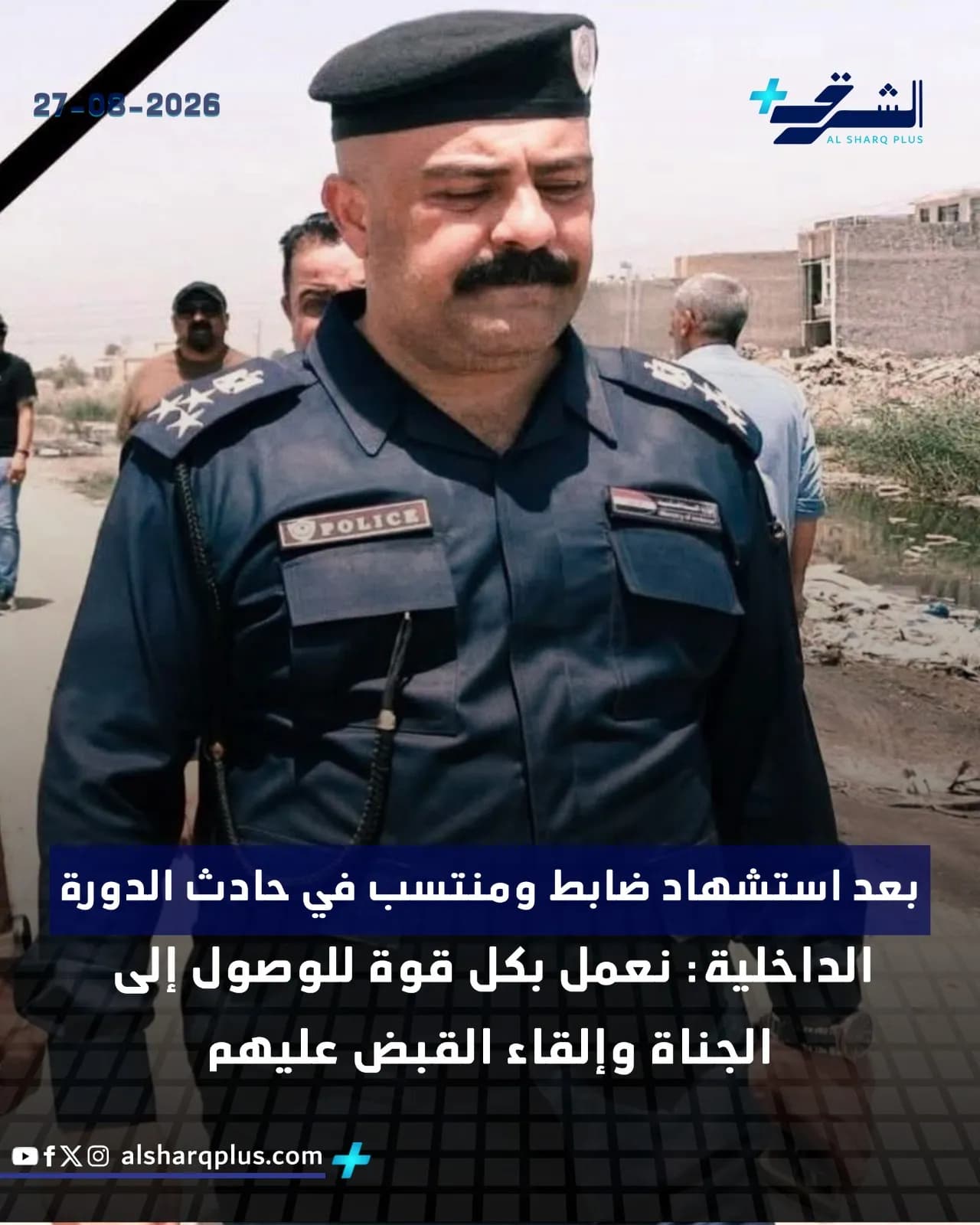 ضابط شرطة عراقي يرتدي زيًا رسميًا أسود وقبعة، يقف في بيئة مفتوحة ذات خلفية صحراوية.