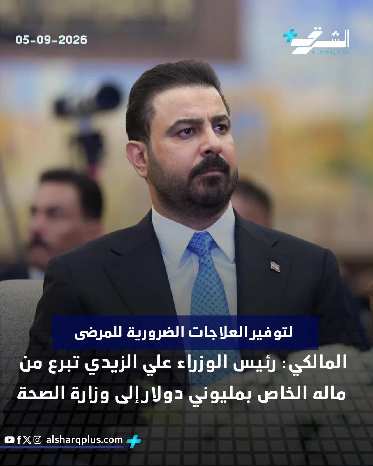 رجل ذو لحية وشارب يرتدي بدلة زرقاء وربطة عنق زرقاء منقوشة ينظر بجدية.