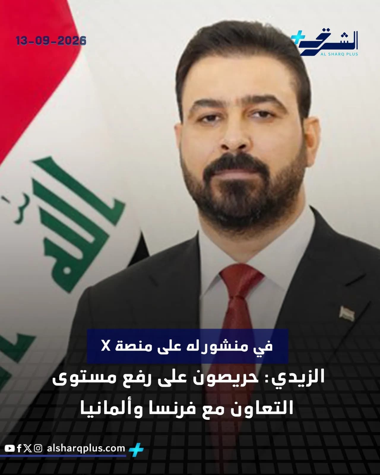 رجل ملتحي يرتدي بدلة وربطة عنق حمراء، يقف أمام العلم العراقي.