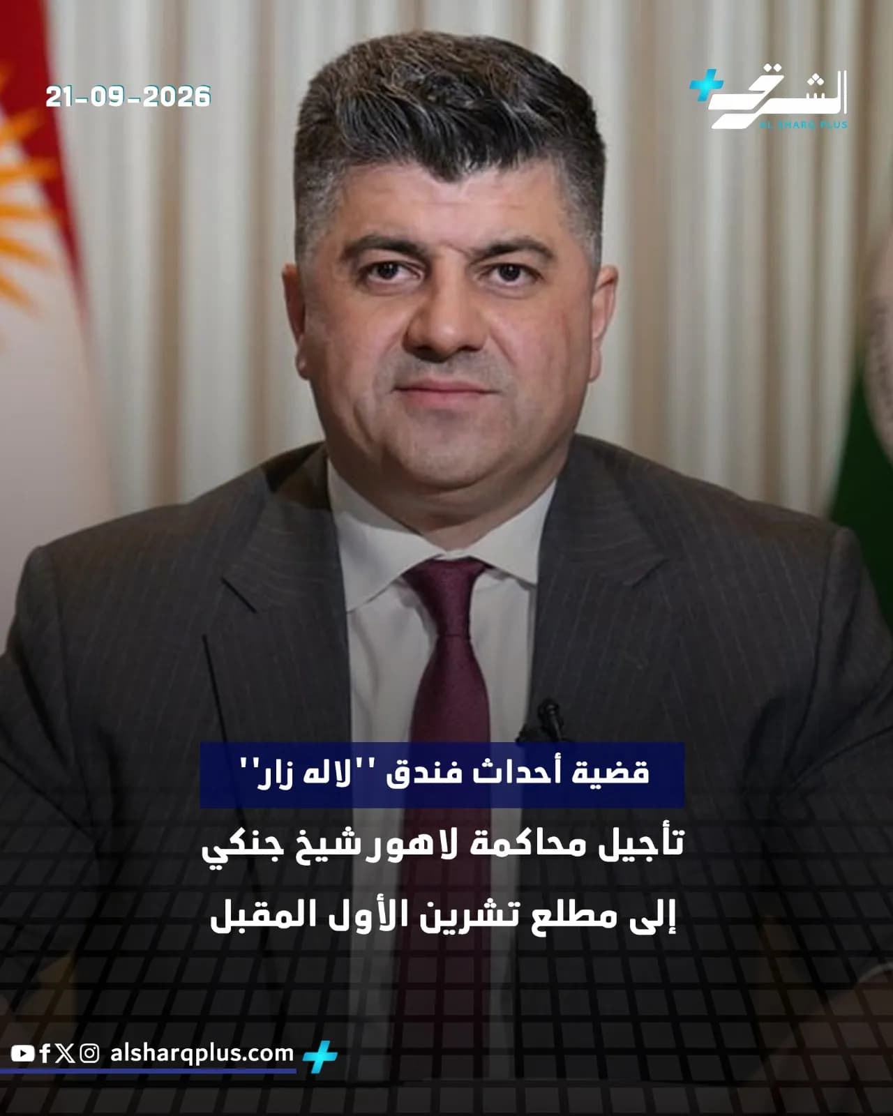 رجل يرتدي بدلة داكنة وربطة عنق قرمزية، وخلفه علم كردستان العراق، ونص عن تأجيل محاكمة.