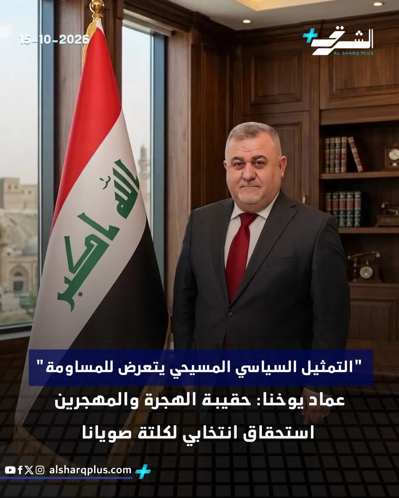 رجل يرتدي بدلة داكنة وربطة عنق حمراء يقف مبتسمًا بجانب علم العراق وخلفه رف كتب.