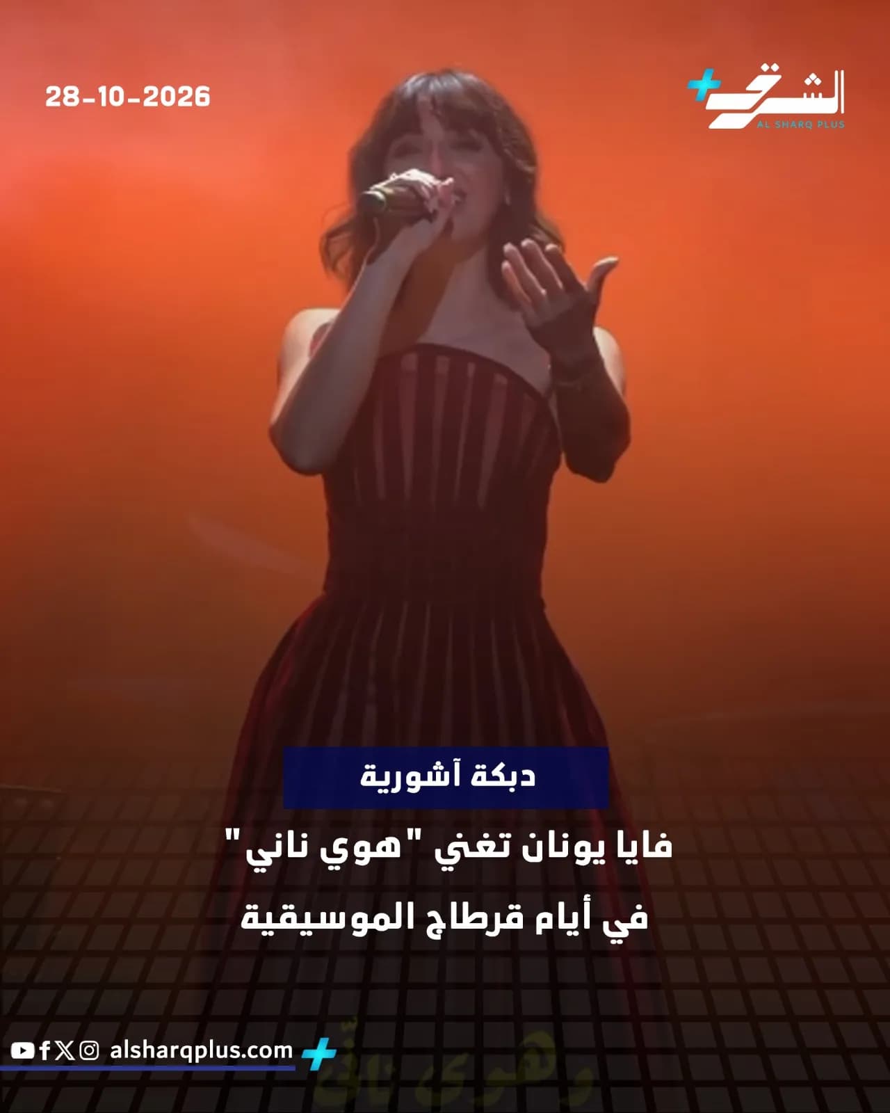 المغنية فايا يونان ترتدي فستانًا أحمر داكن وتغني على خشبة المسرح مع إضاءة برتقالية.