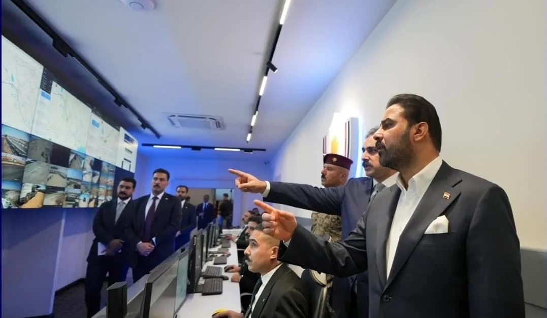 وفد رسمي يضم رجالا ببدلات يقف في غرفة تحكم تراقب شاشات تعرض خرائط وبيانات وكاميرات مراقبة.