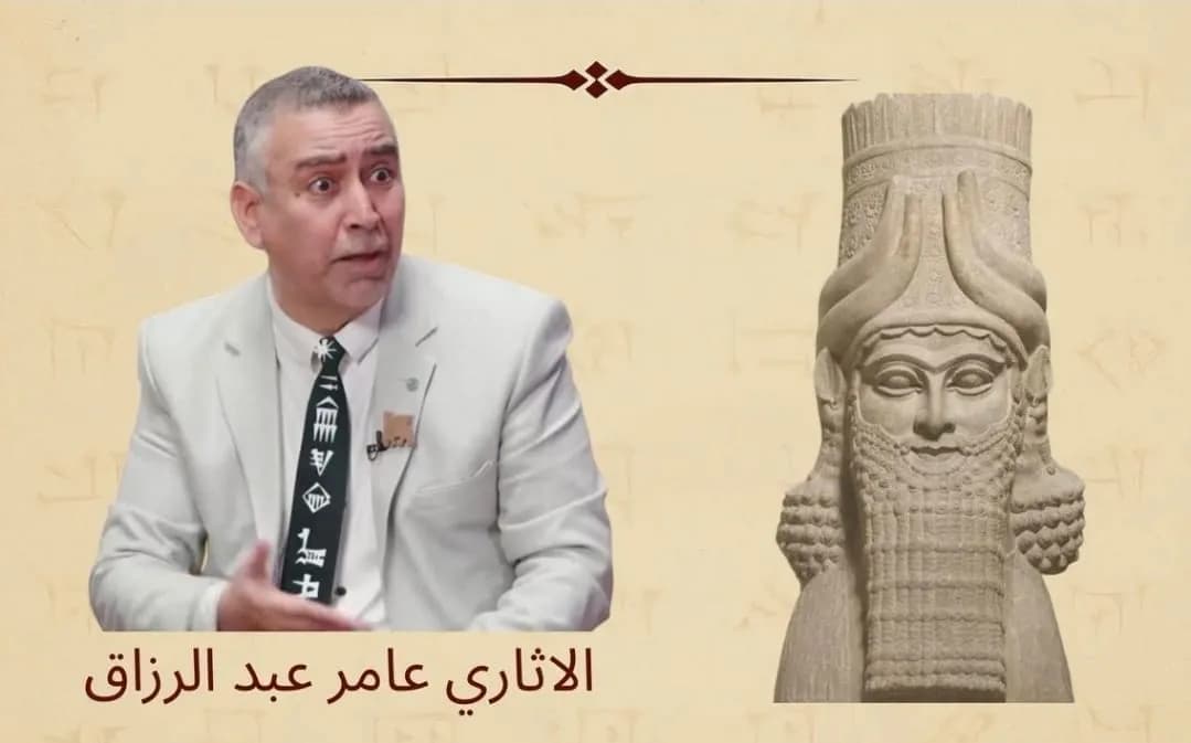 الآثاري عامر عبد الرزاق يتحدث بجانب تمثال آشوري قديم، والخلفية مزينة بنقوش مسمارية.